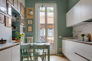 cucina-verde-menta-con-vecchio-tavolo-piano-in-marmo-disegni-alle-pareti