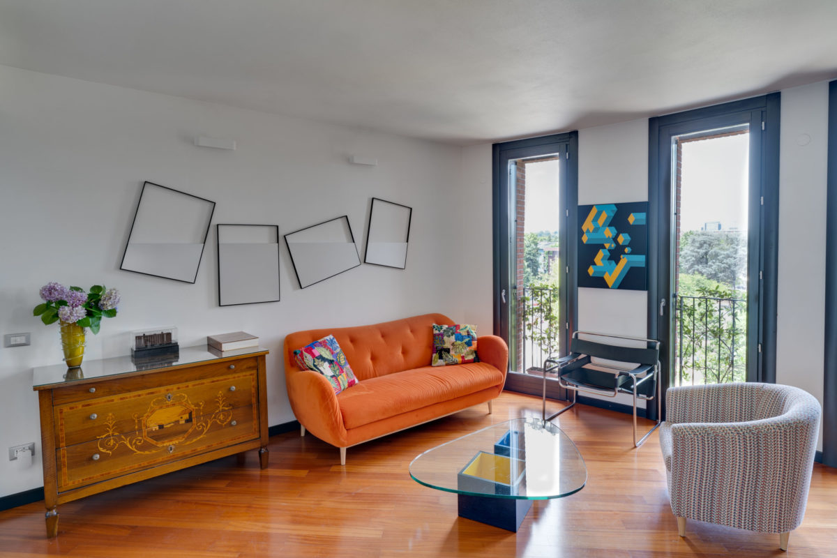 sala-luminosa-divano-arancione-parquet-casa-di collezionisti-muro-tondo-arte-Grazia-Varisco