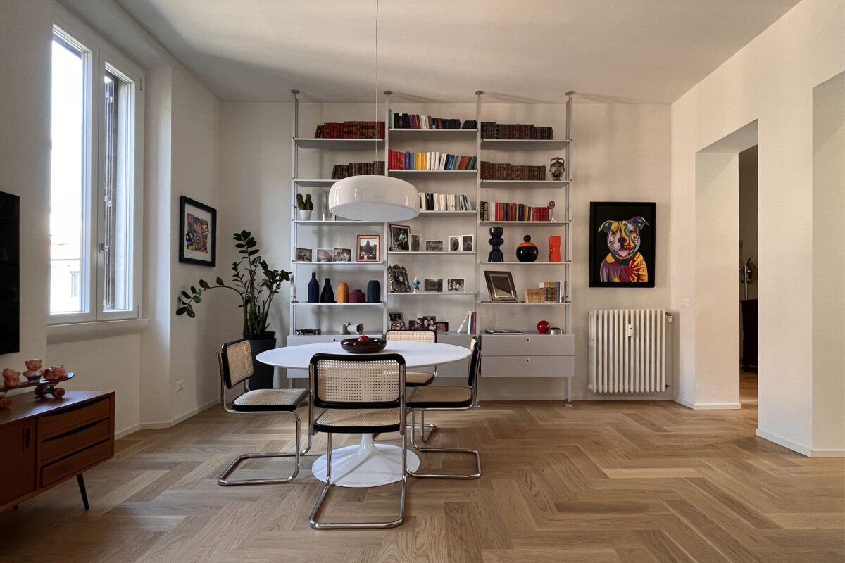 sala-moderna-luminosa-ristrutturata-tavolo-tulip-parquet-a-spina-e-libreria-kriptonite