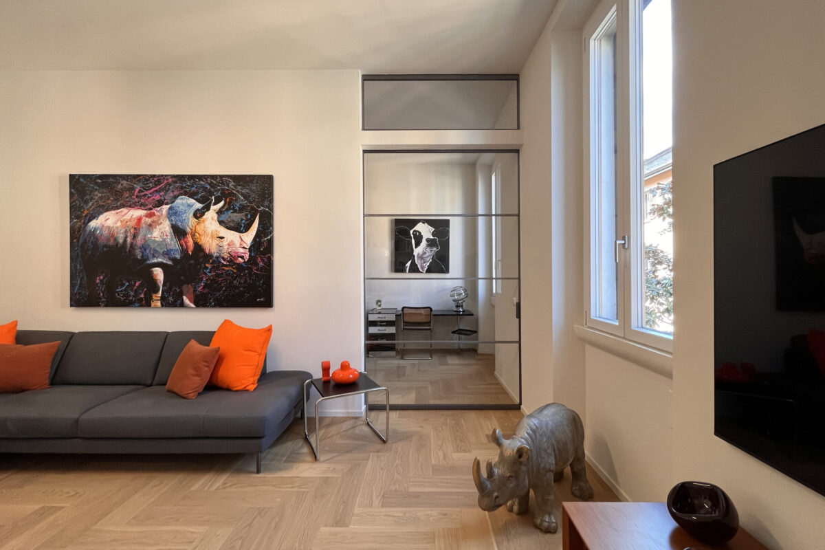 Sala-moderna-ristrutturata-porta-scorrevole-divano-grigio-opere-arte-casa-dei-rinoceronti